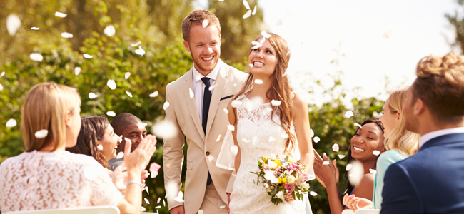Guests Throwing Confetti Over Bride And Groom At Wedding